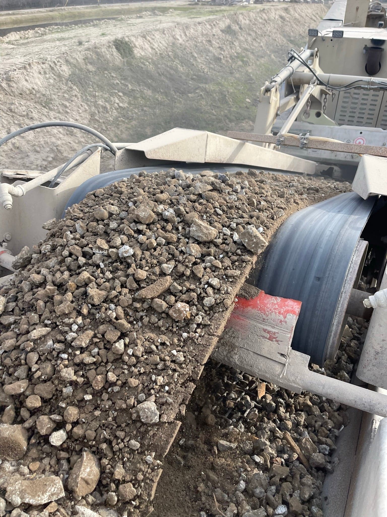 Crushed base rock running off the discharge conveyor of the mobile crusher